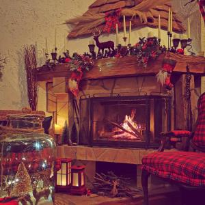 a living room with a fireplace with christmas decorations at Vikendica Despotovic in Bijeljina