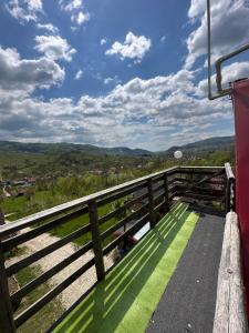 a bench on the side of a balcony with a view at Cabana Tinca in Corbeni