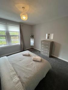 1 dormitorio con 1 cama grande y 2 toallas. en Cosy Cottage Apartment, en Helensburgh