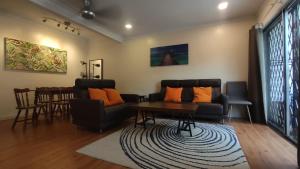 uma sala de estar com um sofá e uma mesa em Cozy-SJ-Family Holidays-Work-BBQ-Tea ceremony-Engagement em Subang Jaya