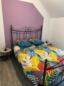 Mont-DolにあるL'ormelais vacancesのベッドルーム1室(カラフルな掛け布団付きのベッド1台付)