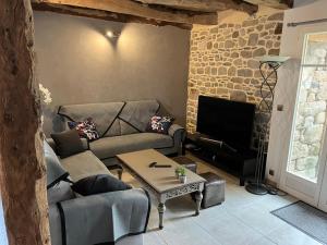 a living room with a couch and a table at L'ormelais vacances in Mont-Dol