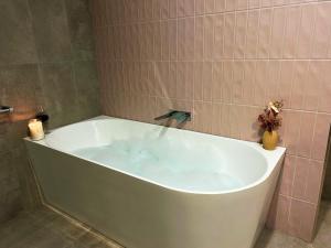 een wit bad met een kraan in de badkamer bij Sullivan House in Benalla