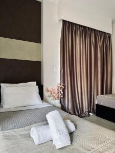 1 dormitorio con 1 cama con 2 toallas en Mc Queen Rooms & Apartments, en Atenas