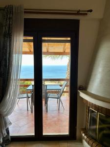 a glass door leading to a patio with a table at Seaview Villa Liandroy in Sellía
