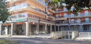 um grande edifício de apartamentos com uma frente de loja em Il giardino segreto em Pietra Ligure