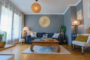 sala de estar con sofá azul y mesa en Manoir 4 étoiles - 2 chambres, proche lac, en Annecy