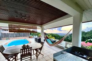a patio with a hammock and a swimming pool at Papeete happiness pool and spas in Papeete