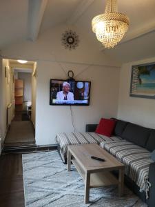 a living room with a couch and a tv on the wall at Minilägenhet in Gothenburg