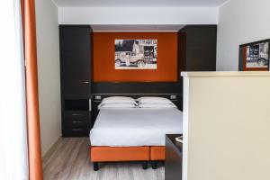 a bedroom with a bed with an orange and black headboard at Hotel Vienna in Lido di Jesolo