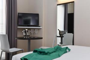 Televízia a/alebo spoločenská miestnosť v ubytovaní Hotel Vienna
