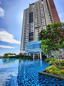 a building with a swimming pool in front of a building at Mevin Woodsbury Suite Butterworth Penang in Butterworth