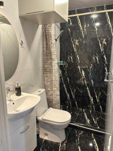 La salle de bains est pourvue de toilettes, d'un lavabo et d'une douche. dans l'établissement WaterFall Hotel, à Erevan
