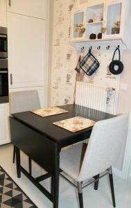 a black table and two chairs in a kitchen at Küstenbude Nachtigall in Grömitz