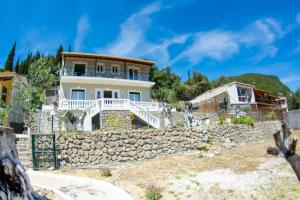 a house on a hill with a stone wall at Nausika Rustic Cottage in Paleokastritsa