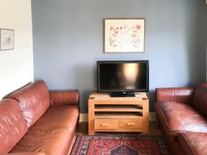 a living room with two leather couches and a flat screen tv at York House in Richmond