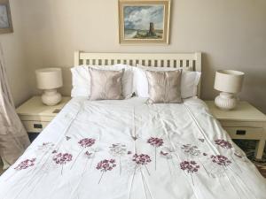 a bed with a white blanket with flowers on it at York House in Richmond