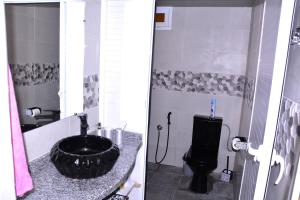 baño con lavabo negro y aseo en Chez zoubida, en Meknès