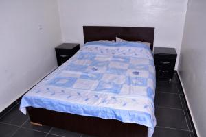 a bed with a blue comforter in a bedroom at Chez zoubida in Meknès