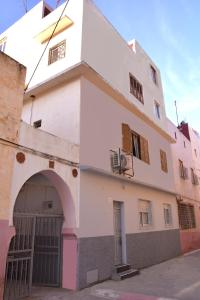 un edificio blanco con un arco delante de él en Chez zoubida, en Meknès