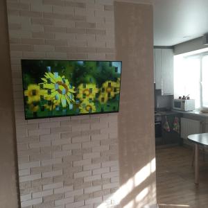 Elle comprend une télévision à écran plat fixée sur un mur en briques. dans l'établissement "Чернігівська тиша", à Tchernihiv
