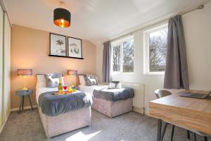 ミルトン・キーンズにあるCentral MK House with Free Parking, Fast Wifi, and Smart TV with Xbox, Sky TV Packages and Netflix by Yoko Propertyのベッド2台とテーブルのあるリビングルーム