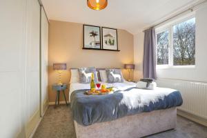 a bedroom with a bed with a tray of fruit on it at Central MK House with Free Parking, Fast Wifi, and Smart TV with Xbox, Sky TV Packages and Netflix by Yoko Property in Milton Keynes