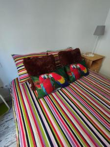 - un lit avec des couvertures et des oreillers colorés dans l'établissement Apartment Barca 1 Camp Nou, à Barcelone