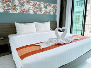 Una cama con dos corazones blancos encima. en Machorat Aonang Resort at Aonang Beach Krabi, en Ao Nang Beach