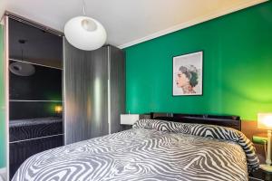 Un dormitorio con una pared verde y una cama en Pop Gallery en León