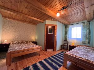 a bedroom with two beds and a wooden ceiling at Zubrowa Ostoja 