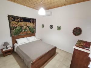 a bedroom with a bed and a painting on the wall at Archangelos House in Archangelos