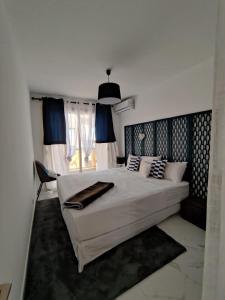 Un dormitorio con una gran cama blanca y una ventana en En exclusivité T3 à 2 pas des plages de St Raphael, en Saint-Raphaël