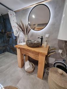 a bathroom with a sink and a mirror on a table at Wiejska Chata in Barczewo