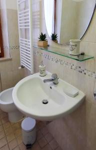 a bathroom with a sink and a toilet and a mirror at I Pini House in Magione