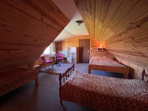 een slaapkamer met 2 bedden in een kamer met houten wanden bij Zubrowa Ostoja in Słobódka