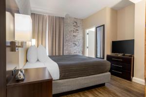 a hotel room with a bed and a flat screen tv at Best Western Plus St. Christopher Hotel in New Orleans