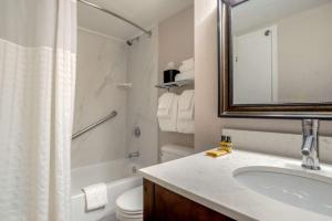 Best Western Plus St. Christopher Hotel في نيو أورلينز: حمام مع حوض ومرحاض ومرآة