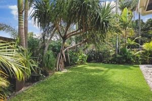 a yard with green grass and palm trees at 300m to beach*Pets allowed*Boho Beach Shack in Maroochydore +12 photos