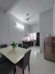 Habitación con mesa, sillas y cocina. en Homestay Taiping Ria, en Simpang