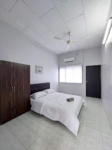 Un dormitorio con una cama grande y una ventana en Homestay Taiping Ria, en Simpang