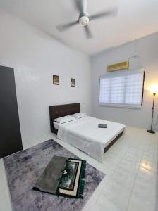 1 dormitorio blanco con 1 cama y ventilador de techo en Homestay Taiping Ria, en Simpang