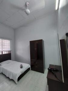 1 dormitorio con 1 cama y vestidor en Homestay Taiping Ria, en Simpang