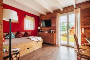 1 dormitorio con paredes rojas y 1 cama con suelo de madera. en Semi-detached houses, turf house, en Torfhaus