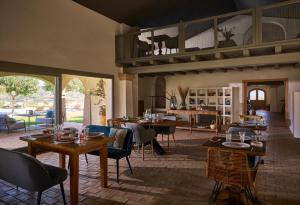 a living room with tables and chairs and a kitchen at Cascioni Eco Retreat in Arzachena