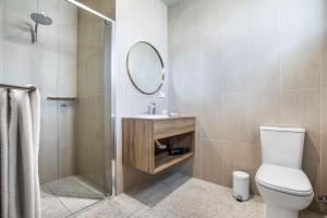 uma casa de banho com um WC, um chuveiro e um espelho. em Nightcap at Empire Hotel em Gepps Cross