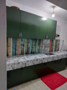 eine Küche mit grünen Schränken und einer Arbeitsplatte in der Unterkunft A sweet house for families, in Üsküdar in Istanbul