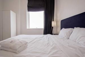 een wit bed in een slaapkamer met een raam bij StoneTree - Botanica Tower 1 BR - Close to Beach in Dubai