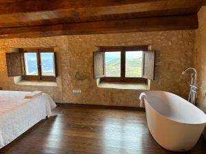 a bedroom with a tub and a bed and windows at Charme in Perillis in Popoli