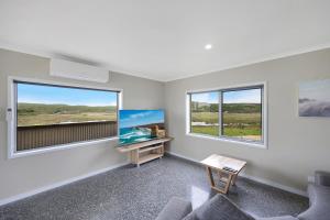 a living room with two windows and a desk at Otway Coastal Villas, 1 Bedroom villa. in Princetown